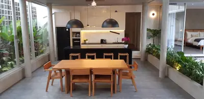 a kitchen and dining room with a wooden table and chairs at Villa Mandja - Stunning architect-designed 3BR villa in Petitenget in Seminyak