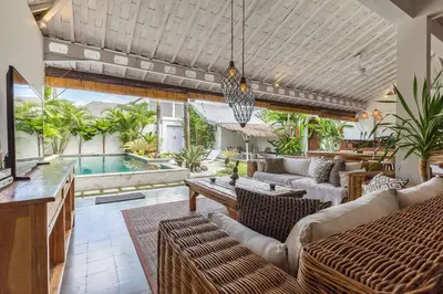 a living room with a couch and a swimming pool at Villa Madura DREAM 3bdrs Central Seminyak in Seminyak