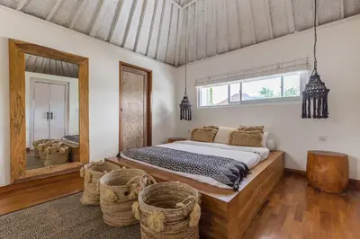 a bedroom with a large bed and a mirror at Villa Madura DREAM 3bdrs Central Seminyak in Seminyak