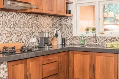 a kitchen with wooden cabinets and a counter top at Relax Bali Villas in Legian