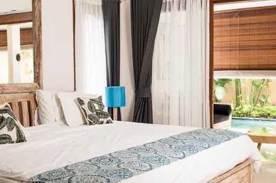 a bedroom with a bed and a view of a pool at Relax Bali Villas in Legian