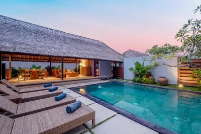 a villa with a swimming pool and a resort at Kundalini Residence in Seminyak