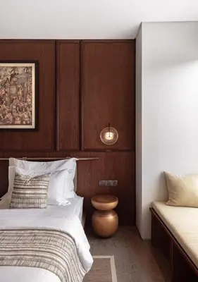 a bedroom with two beds and a wooden wall at Munno Villa in Canggu