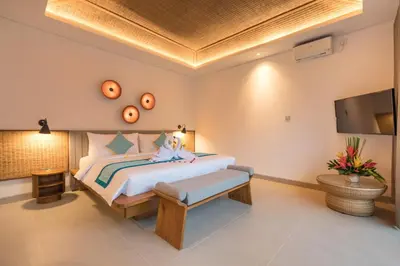 a bedroom with a bed and a flat screen tv at Fenosa Seminyak Villas in Seminyak