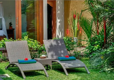 two wicker chairs sitting on the grass in a yard at Villa Andalas in Seminyak