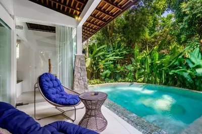 a patio with a pool and chairs and a table at Umani Village in Kerobokan