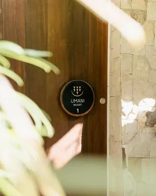 a black sign on a door with a crown on it at Umani Village in Kerobokan
