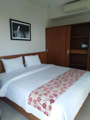 a bedroom with a large white bed with flowers on it at LBV Seminyak Apartment in Seminyak