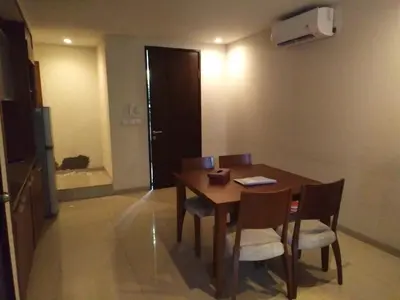 a dining room with a wooden table and chairs at LBV Seminyak Apartment in Seminyak