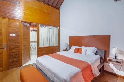 a bedroom with a large bed with a wooden headboard at Villa Padma by Best Deals Asia Hospitality in Nusa Dua