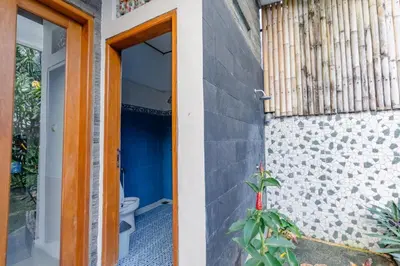 a bathroom with a toilet next to a door at Villa Padma by Best Deals Asia Hospitality in Nusa Dua