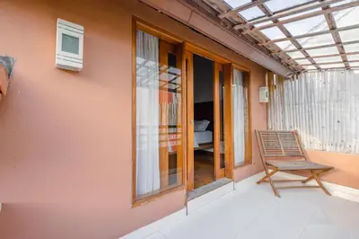 a balcony with a chair and a bedroom at Villa Padma by Best Deals Asia Hospitality in Nusa Dua
