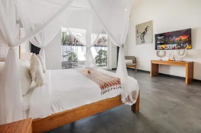a bedroom with a bed with a canopy at Villa Zebra Walking Distance to Potato Head in Seminyak