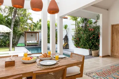 a dining room with a table with food on it at Villa Gauguin by Villa Finder in Seminyak