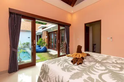 a bedroom with a bed with a teddy bear on it at Villa Kamboja Premium walk to double six Beach - enclosed living room with AC in Seminyak