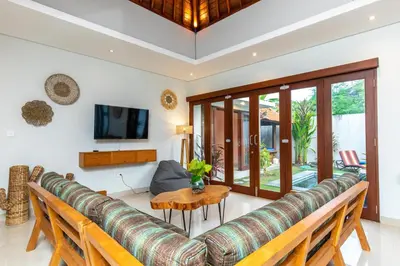 a living room with a couch and a table at Villa Kamboja Premium walk to double six Beach - enclosed living room with AC in Seminyak