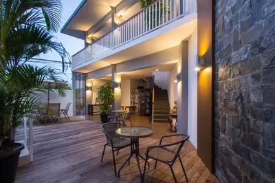 a patio with a table and chairs and a brick wall at M Suite Bali in Seminyak
