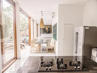 a kitchen with a stove top oven next to a table at AB Villa & Apartments in Seminyak