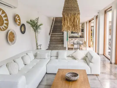 a living room with a white couch and a table at AB Villa & Apartments in Seminyak