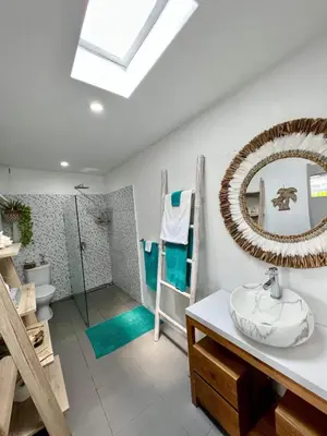 a bathroom with a sink and a mirror at Tiga Pantai Villa Legian in Legian