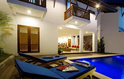 a house with a swimming pool next to a house at Delu Villas & Suite in Kerobokan