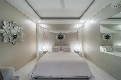 a bedroom with a large bed and a mirror at VILLA BALI OM CENTER - Best Location, Beautiful Villa Near the Beach in Canggu