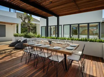 a dining table and chairs on a wooden deck at Villa Nini Elly by Elite Havens in Canggu