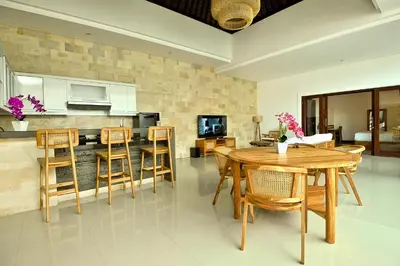 a kitchen and dining room with a wooden table and chairs at Villa Casey in Seminyak