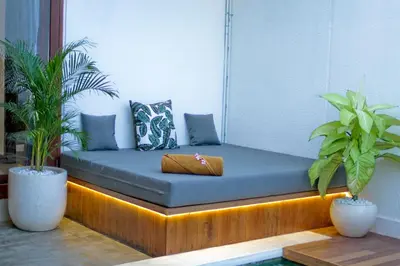 a couch sitting in a room with two plants at Villa Casey in Seminyak