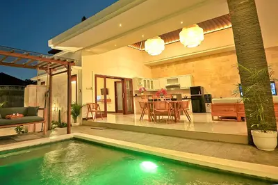 a house with a swimming pool in front of a house at Villa Casey in Seminyak