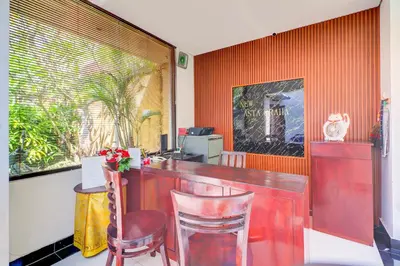 a red bar with two stools in a restaurant at Collection O Bali near Kedonganan Beach formerly New Asta Graha Homestay in Jimbaran