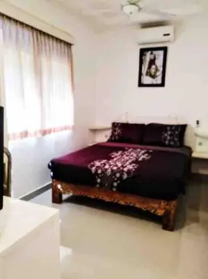 a bedroom with a bed with a bench in it at Blue Lagoon 5 bedrooms Villa in Kuta