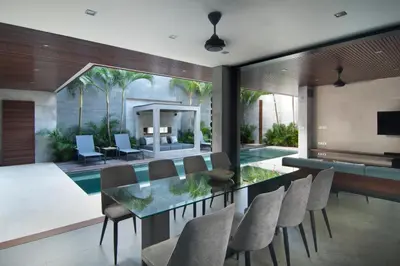 a dining room with a glass table and chairs at 4BR Villa Jumat - Minggu Villas Seminyak in Seminyak