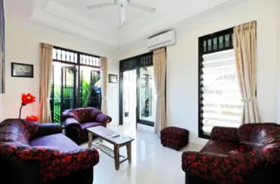 a living room with couches and a table and windows at Blue Lagoon Apartment 3br in Kuta