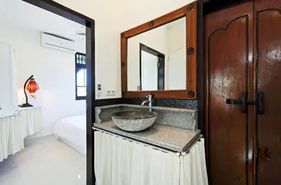 a bathroom with a sink and a mirror at Blue Lagoon Apartment 3br in Kuta