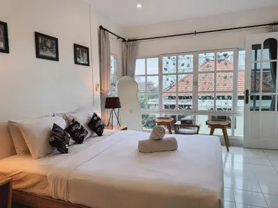 a bedroom with a large bed with a large window at Beach House Apartment in Legian