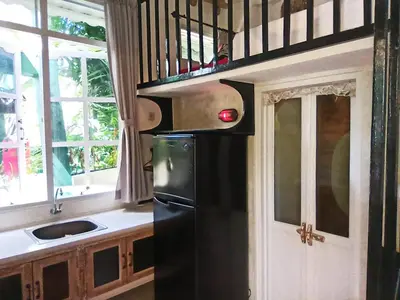 a kitchen with a black refrigerator and a sink at Beach House Apartment in Legian