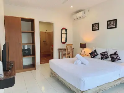 a bedroom with a bed and a tv in a room at Beach House Apartment in Legian