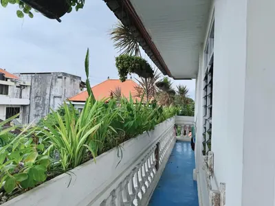 a balcony of a house with plants on it at Beach House Apartment in Legian