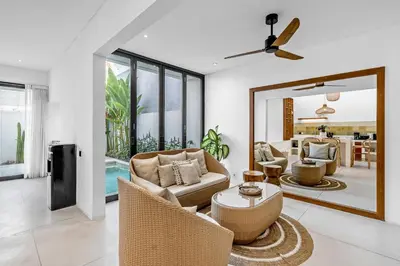 a living room with chairs and a table and a mirror at Besso Villa by Betterplace in Canggu