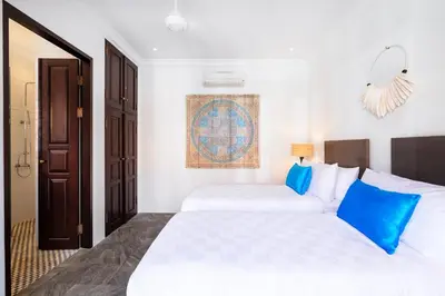 a bedroom with two beds with blue pillows at Villa Rua - Stylish luxury, tranquil location in Legian, walk to beach in Seminyak