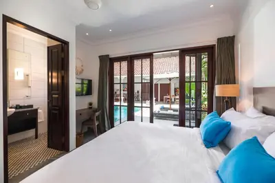 a bedroom with a bed and a desk and a bathroom at Villa Tahi - Stylish luxury, tranquil location, walk to beach in Legian