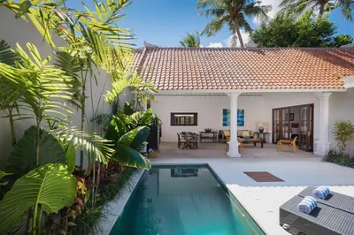 a villa with a swimming pool in front of a house at Villa Toru - Stylish luxury in Legian, tranquil location, walk to beach in Legian