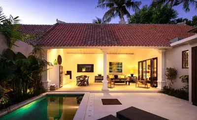 a villa with a swimming pool in front of a house at Villa Toru - Stylish luxury in Legian, tranquil location, walk to beach in Legian