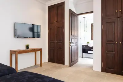 a bedroom with a bed and a tv on a wall at Villa Toru - Stylish luxury in Legian, tranquil location, walk to beach in Legian