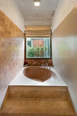 a large bath tub in a bathroom with a window at Bracha Villas Bali in Seminyak