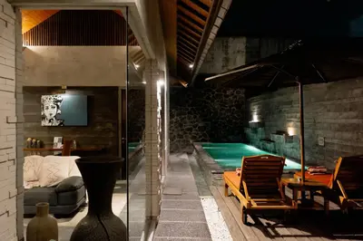a living room with a swimming pool and a house at Bracha Villas Bali in Seminyak