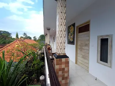 a balcony of a house with a pillar at Roy Guest House in Canggu