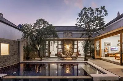 a house with a pool in the middle of a yard at Bali Voyage in Seminyak