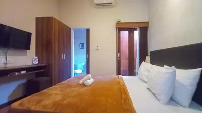 a hotel room with a bed with two towels on it at Andewi Homestay RedPartner - Minimum Stay 30 Nights in Pesanggaran